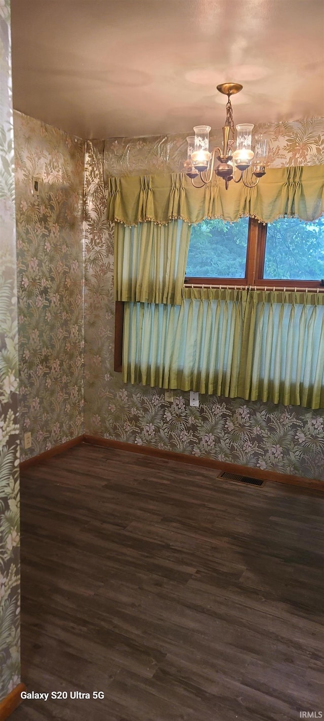 1202 N Sheridan Rd, Marion, IN 46952 - spare room with wood finished floors, baseboards, wallpapered walls, and a chandelier