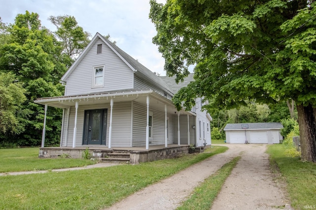 1113 Harrison St, Walkerton, IN 46574 - view of front of house with covered porch, an outdoor structure, a front lawn, and a garage