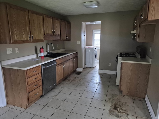 435 N Main St, Mulberry, IN 46058 - kitchen with white range with gas stovetop, dishwasher, a sink, washing machine and dryer, and light countertops