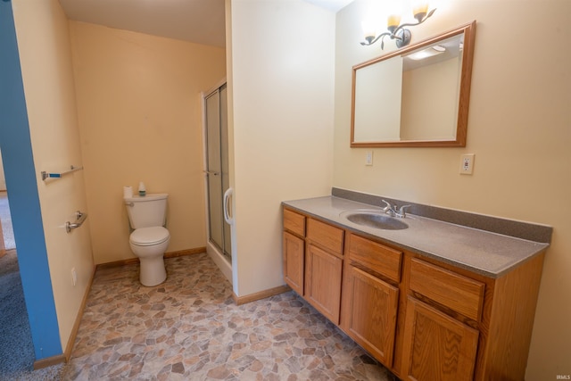 7768 S 100 W, North Judson, IN 46366 - bathroom featuring toilet, stone finish floors, vanity, a shower with shower door, and baseboards