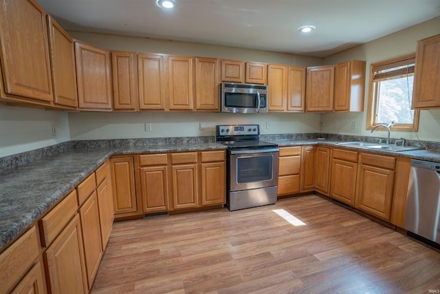 7768 S 100 W, North Judson, IN 46366 - kitchen featuring stainless steel appliances, a sink, recessed lighting, dark countertops, and light wood-type flooring