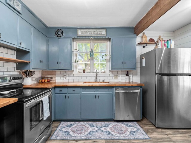 2728 E Dr, Fort Wayne, IN 46805 - kitchen with appliances with stainless steel finishes, a sink, butcher block countertops, blue cabinets, and beam ceiling