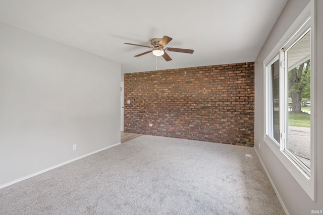 1813 Crescent Dr, Warsaw, IN 46580 - unfurnished room with brick wall, ceiling fan, plenty of natural light, baseboards, and carpet floors