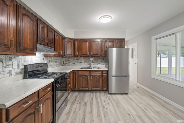 1813 Crescent Dr, Warsaw, IN 46580 - kitchen with stainless steel appliances, under cabinet range hood, a sink, decorative backsplash, and light countertops