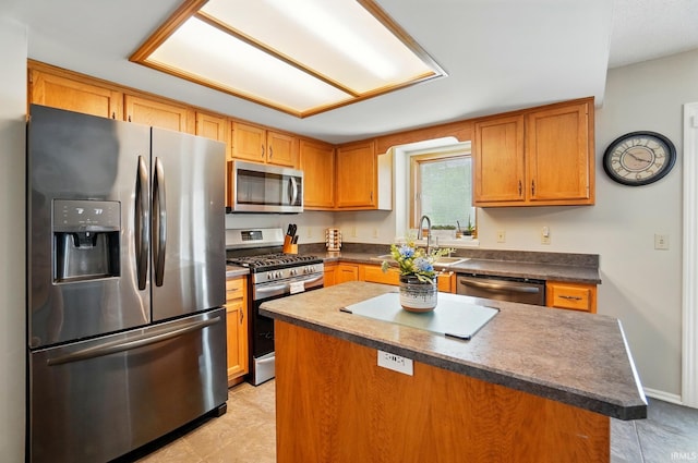 8427 Victoria Woods Pl, Fort Wayne, IN 46825 - kitchen featuring stainless steel appliances, a sink, dark countertops, a center island, and light tile patterned floors