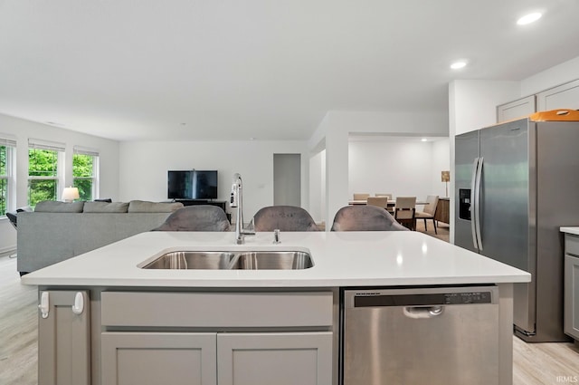 7756 Haven Blvd, Fort Wayne, IN 46804 - kitchen featuring appliances with stainless steel finishes, a sink, light wood-style floors, open floor plan, and a center island with sink