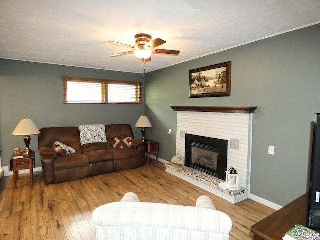 105 Shawnee Dr, Bedford, IN 47421 - living area with ceiling fan, wood finished floors, baseboards, a brick fireplace, and crown molding