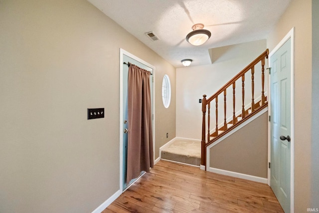 1544 Shining Armor Ln, West Lafayette, IN 47906 - foyer with wood finished floors, stairway, baseboards, and a textured ceiling