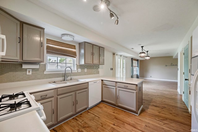 1544 Shining Armor Ln, West Lafayette, IN 47906 - kitchen featuring white appliances, a sink, a peninsula, a chandelier, and light wood-style flooring