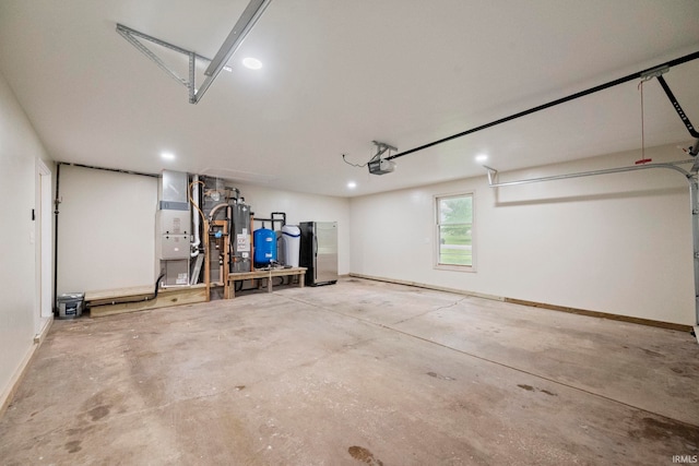 2213 Old Oak Dr, West Lafayette, IN 47906 - garage featuring a garage door opener, freestanding refrigerator, recessed lighting, baseboards, and heating unit