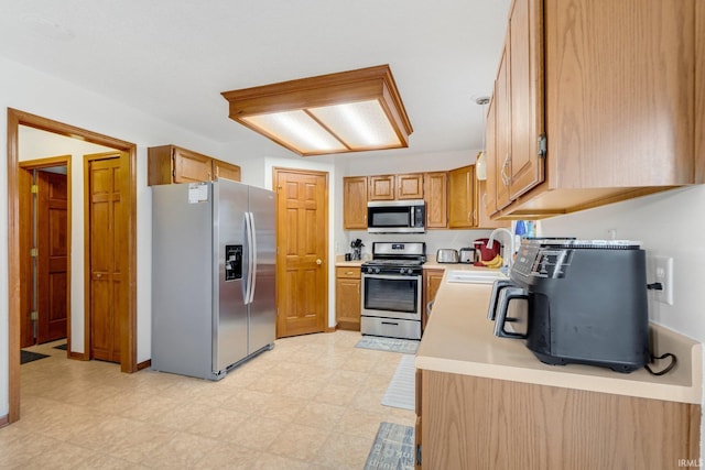 5531 Gate Tree Ln, Fort Wayne, IN 46835 - kitchen with stainless steel appliances, light countertops, light flooring, a sink, and brown cabinetry
