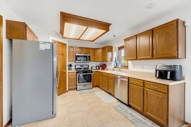 5531 Gate Tree Ln, Fort Wayne, IN 46835 - kitchen featuring appliances with stainless steel finishes, a sink, brown cabinetry, light flooring, and light countertops