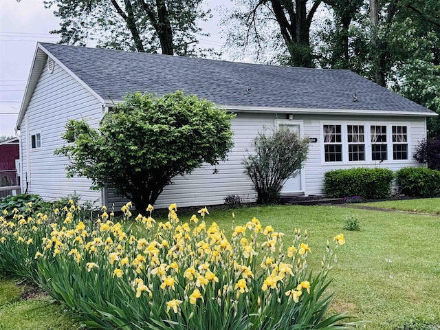 1005 Elm St, Plymouth, IN 46563 - view of side of property featuring roof with shingles and a lawn