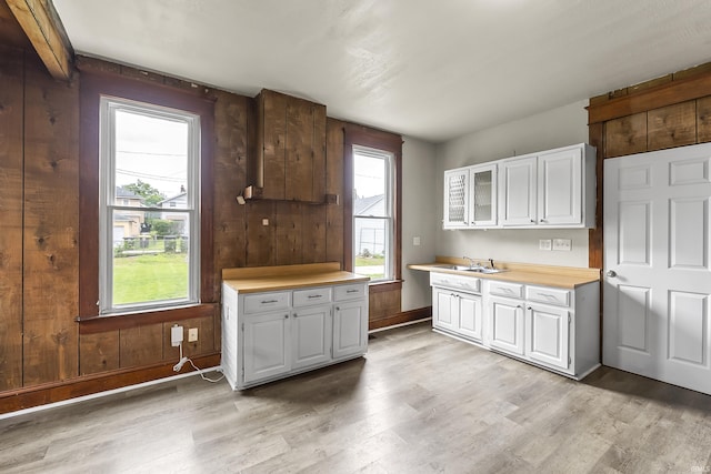 2121 Parnell Ave, Fort Wayne, IN 46805 - kitchen featuring light wood-style flooring, light countertops, white cabinets, a sink, and glass insert cabinets