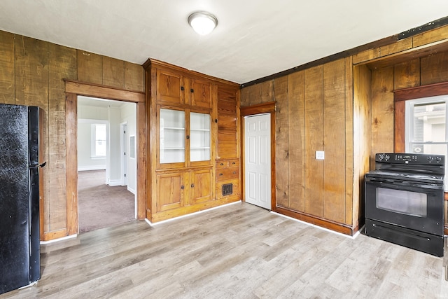 2121 Parnell Ave, Fort Wayne, IN 46805 - kitchen featuring black appliances, light wood-style floors, and wooden walls
