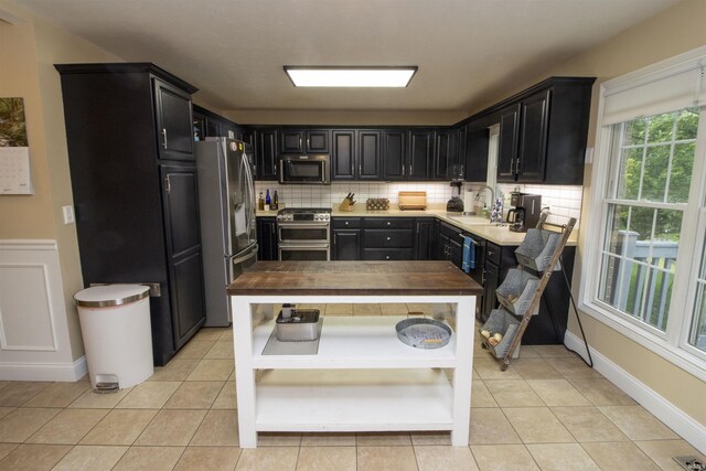 917 E Mill Creek Rd, Greensburg, IN 47240 - kitchen with appliances with stainless steel finishes, a sink, dark cabinetry, and decorative backsplash