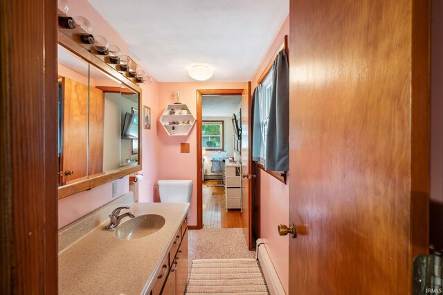 907 N Orchard Dr, North Manchester, IN 46962 - bathroom featuring vanity, toilet, a baseboard radiator, and wood finished floors