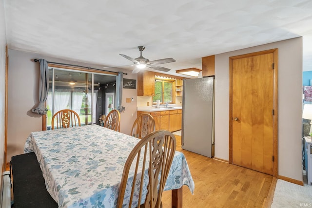907 N Orchard Dr, North Manchester, IN 46962 - dining room featuring light wood-style floors, ceiling fan, baseboards, and a baseboard heating unit