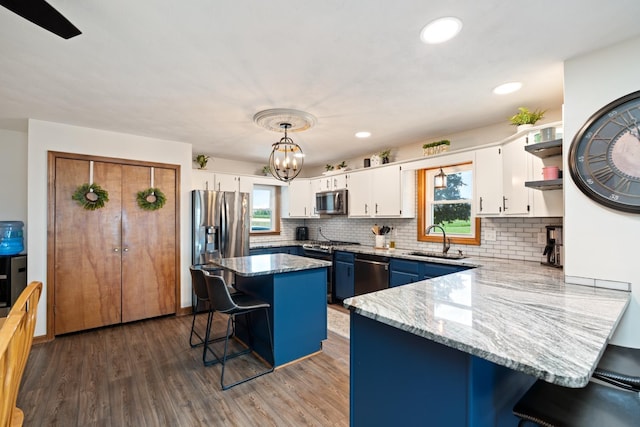 3705 E Forest Glen Ave, Leesburg, IN 46538 - kitchen featuring appliances with stainless steel finishes, a sink, a breakfast bar, white cabinetry, and healthy amount of natural light
