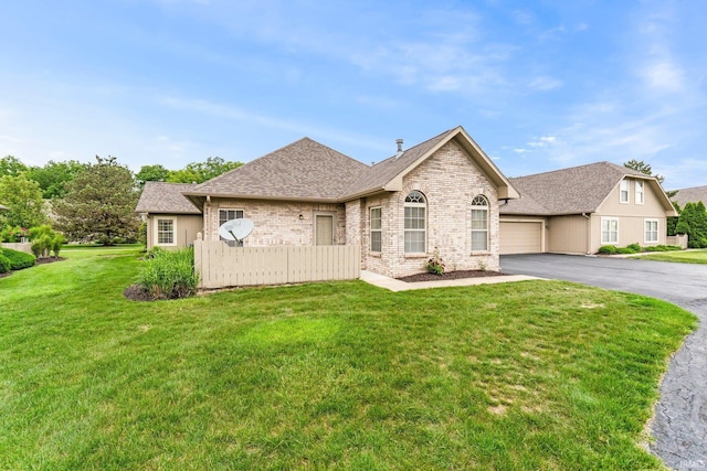 5248 Coventry Ln, Fort Wayne, IN 46804 - french country inspired facade with asphalt driveway, a garage, a front yard, brick siding, and roof with shingles