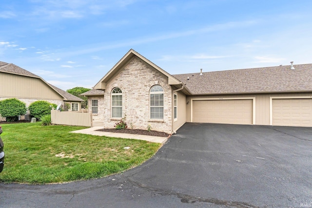 5248 Coventry Ln, Fort Wayne, IN 46804 - view of front facade with a garage, asphalt driveway, a front lawn, and roof with shingles