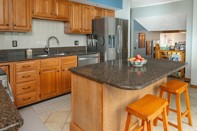 4641 W Harvest Ln, Bloomington, IN 47404 - kitchen with appliances with stainless steel finishes, a sink, tasteful backsplash, a kitchen breakfast bar, and dark stone counters