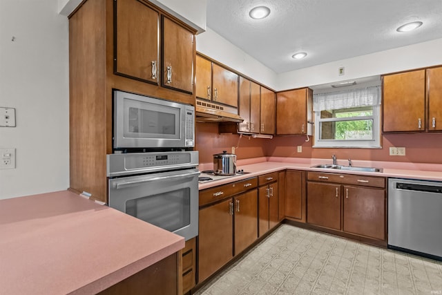 1105 E Southway Blvd, Kokomo, IN 46902 - kitchen with appliances with stainless steel finishes, a sink, under cabinet range hood, light countertops, and brown cabinets