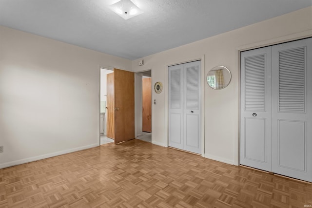 1105 E Southway Blvd, Kokomo, IN 46902 - unfurnished bedroom featuring multiple closets, baseboards, and a textured ceiling