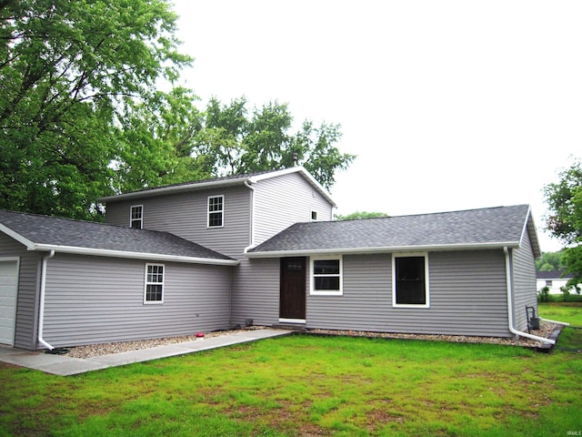 25123 Snyder St, Elkhart, IN 46514 - back of house featuring a garage, a yard, and roof with shingles