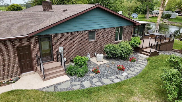4630 E Armstrong Rd, Leesburg, IN 46538 - rear view of house with a deck, a shingled roof, brick siding, and a lawn