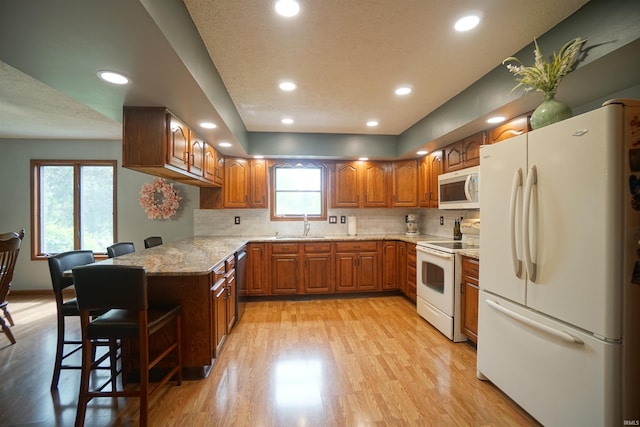 4630 E Armstrong Rd, Leesburg, IN 46538 - kitchen with white appliances, a sink, light wood-type flooring, brown cabinets, and decorative backsplash
