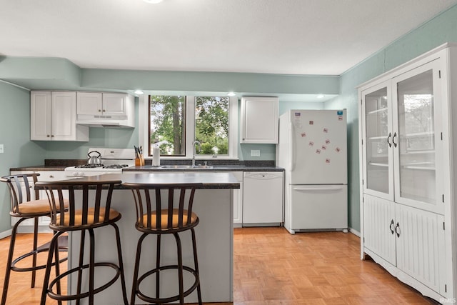 726 S Johnson, Bluffton, IN 46714 - kitchen featuring white appliances, dark countertops, a breakfast bar, and white cabinetry