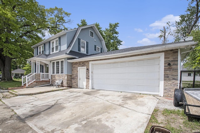 1224 N Main St, Elkhart, IN 46514 - view of front of property with stone siding, a gambrel roof, driveway, roof with shingles, and an attached garage