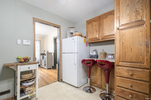 1224 N Main St, Elkhart, IN 46514 - kitchen with freestanding refrigerator and brown cabinets