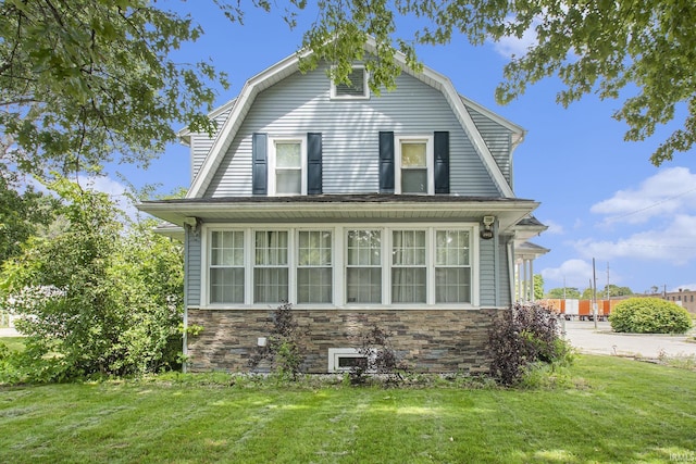 1224 N Main St, Elkhart, IN 46514 - dutch colonial featuring a gambrel roof, a front lawn, and stone siding