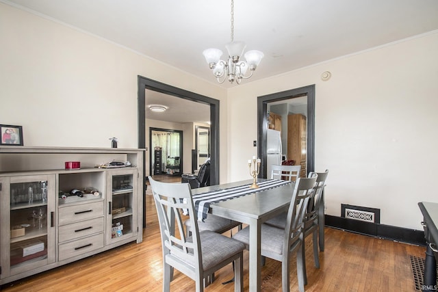 1224 N Main St, Elkhart, IN 46514 - dining area featuring a chandelier, light wood-style floors, crown molding, and baseboards
