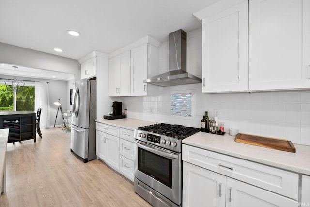 1718 Churchill Dr, South Bend, IN 46617 - kitchen with wall chimney range hood, appliances with stainless steel finishes, light countertops, white cabinets, and light wood-style flooring