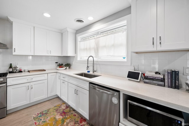 1718 Churchill Dr, South Bend, IN 46617 - kitchen featuring appliances with stainless steel finishes, a sink, backsplash, white cabinets, and recessed lighting