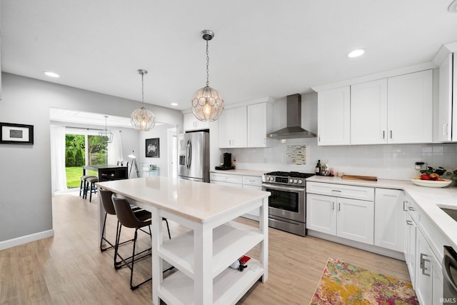 1718 Churchill Dr, South Bend, IN 46617 - kitchen featuring wall chimney exhaust hood, appliances with stainless steel finishes, light countertops, decorative backsplash, and light wood-style floors