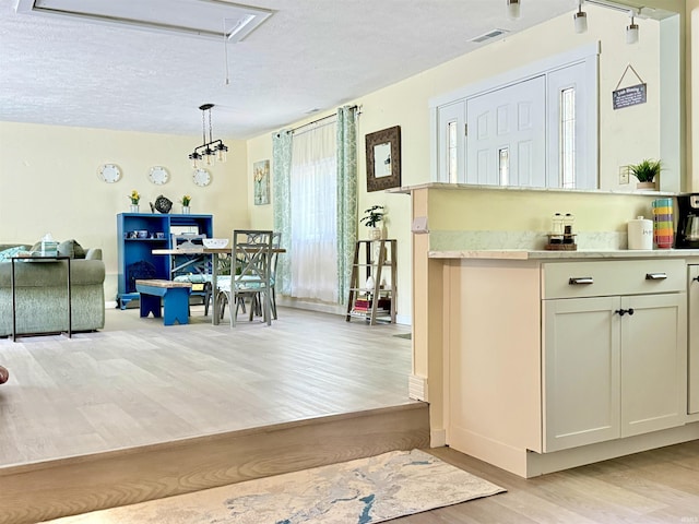 0731 S June Dr, Cromwell, IN 46732 - kitchen with light wood-style flooring, a textured ceiling, light countertops, open floor plan, and pendant lighting