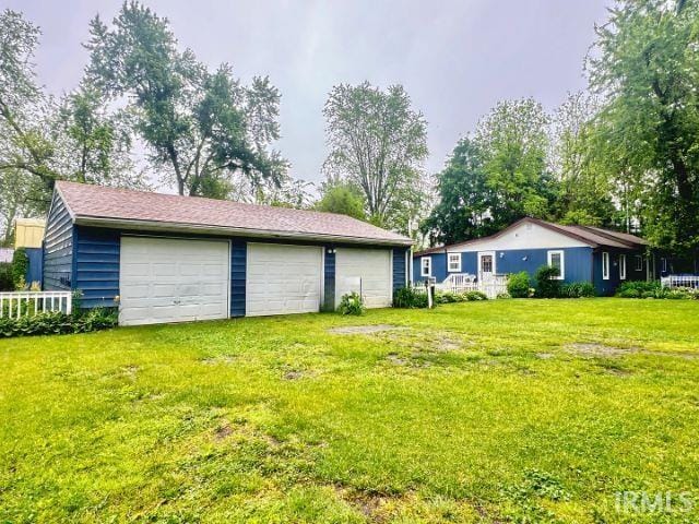 0731 S June Dr, Cromwell, IN 46732 - view of green lawn featuring a detached garage and an outbuilding