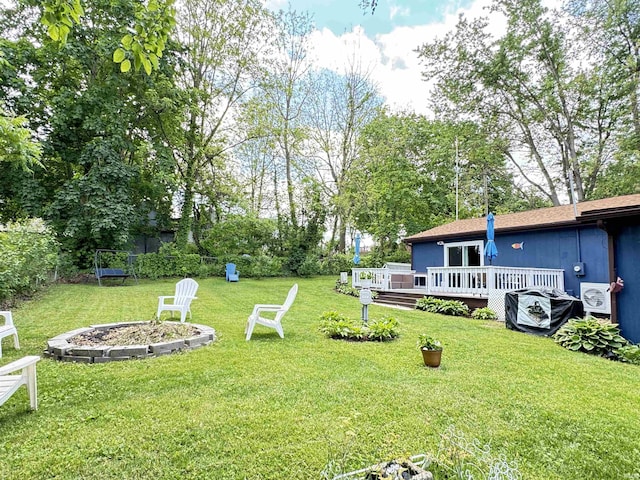 0731 S June Dr, Cromwell, IN 46732 - view of green lawn with a fire pit, a wooden deck, and view of wooded area