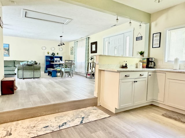 0731 S June Dr, Cromwell, IN 46732 - kitchen with light wood-style flooring, light countertops, pendant lighting, white cabinetry, and rail lighting