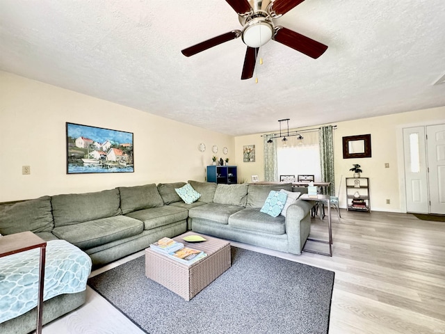 0731 S June Dr, Cromwell, IN 46732 - living area with a textured ceiling, light wood-style flooring, a ceiling fan, and baseboards