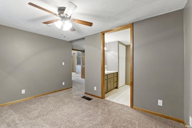 714 Hazel St, Auburn, IN 46706 - unfurnished bedroom featuring light carpet, baseboards, ensuite bathroom, and ceiling fan