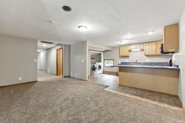 714 Hazel St, Auburn, IN 46706 - kitchen with washer and dryer, a peninsula, light colored carpet, open floor plan, and baseboards