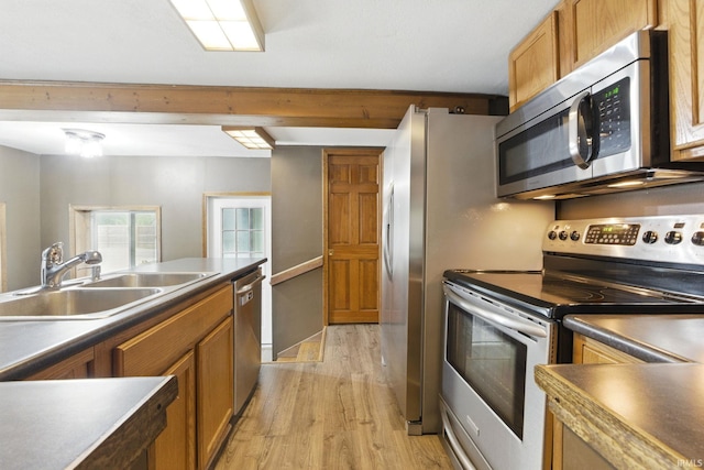 714 Hazel St, Auburn, IN 46706 - kitchen with appliances with stainless steel finishes, a sink, light wood-style floors, brown cabinets, and dark countertops