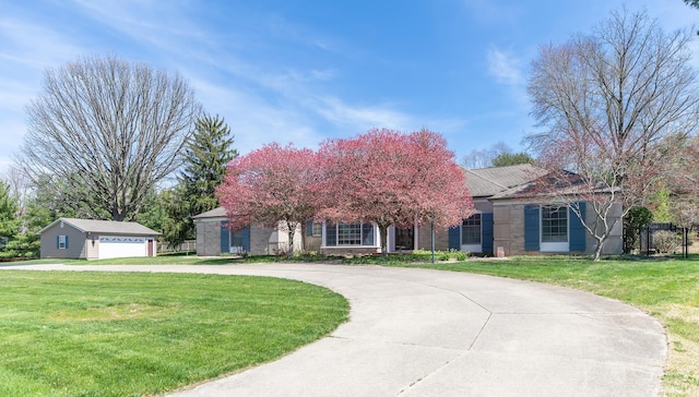 4000 E Stonegate Dr, Bloomington, IN 47401 - view of property hidden behind natural elements featuring a front yard, curved driveway, and a detached garage
