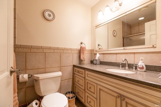 4000 E Stonegate Dr, Bloomington, IN 47401 - bathroom with vanity, toilet, a shower with shower door, tile walls, and wainscoting
