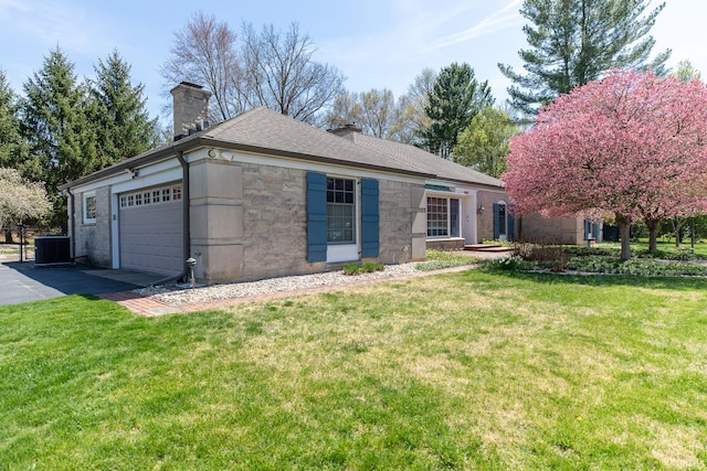 4000 E Stonegate Dr, Bloomington, IN 47401 - view of front facade featuring an attached garage, a chimney, stone siding, and a front yard